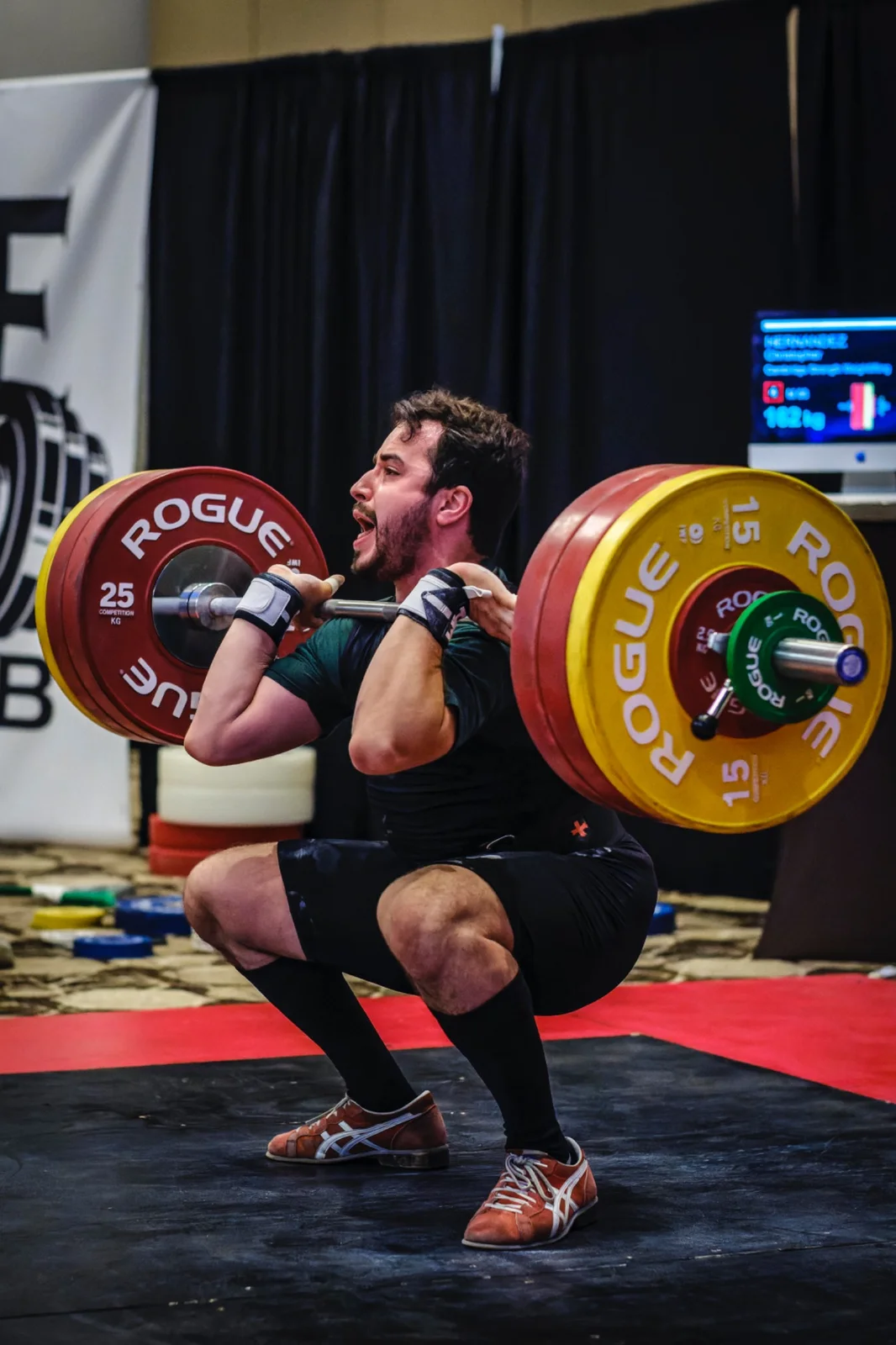 USAW Certified Coach Christopher Hernandez completing a clean at a weightlifting competition