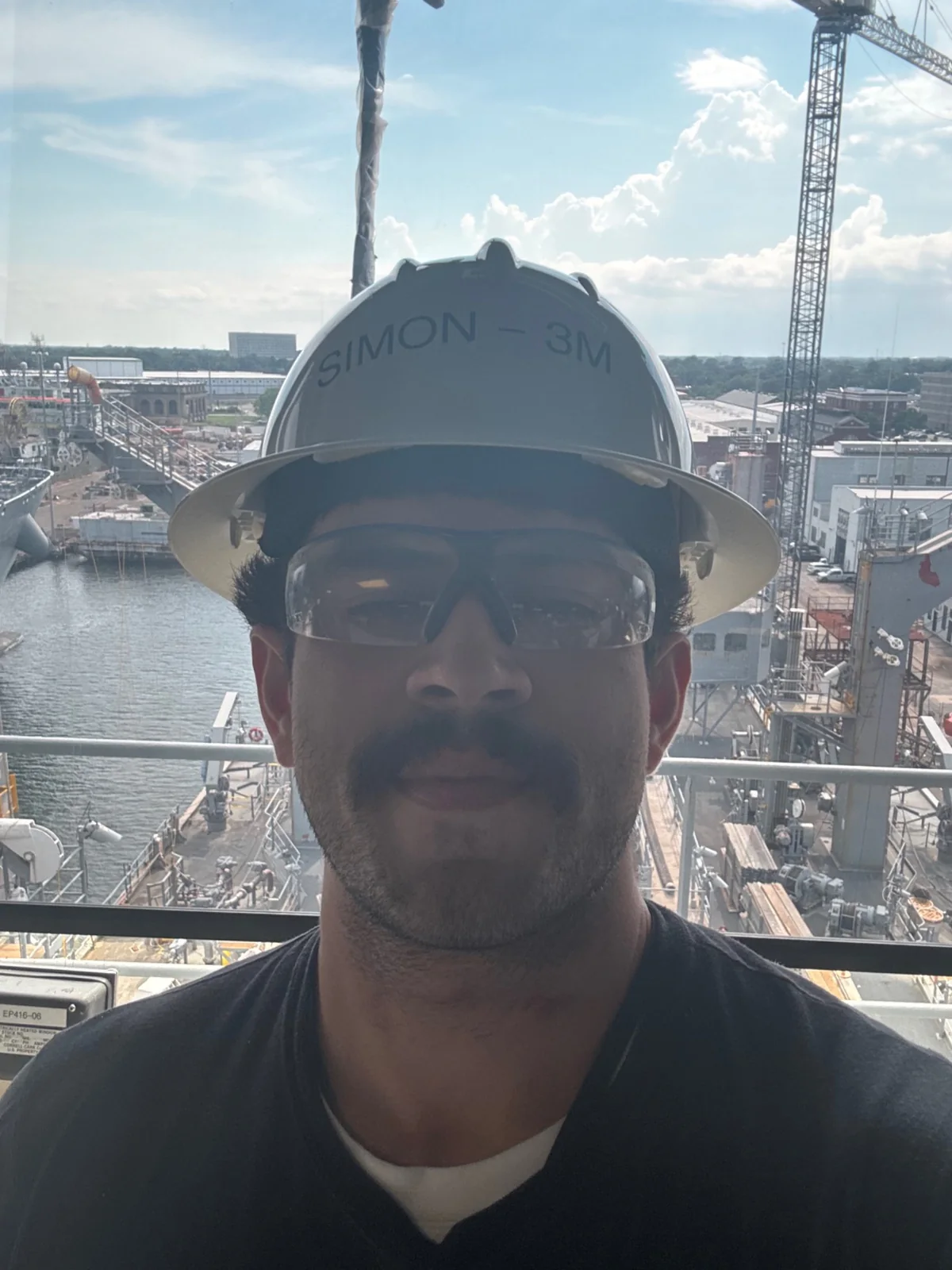 Simon Varela working aboard a ship in a hard hat and safety glasses